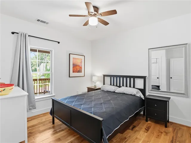 Warm hardwood flooring pairs with a classic multi-lite window in this inviting bedroom.