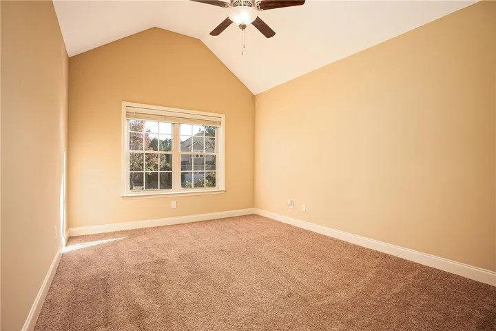 Vaulted ceilings and plush carpeting enhance this inviting space filled with natural light.