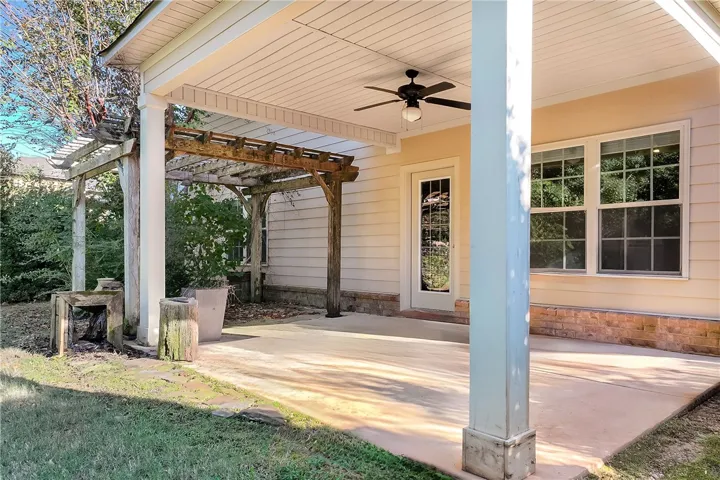 Sheltered outdoor living transitions seamlessly to a wooden garden pergola alongside the lawn.