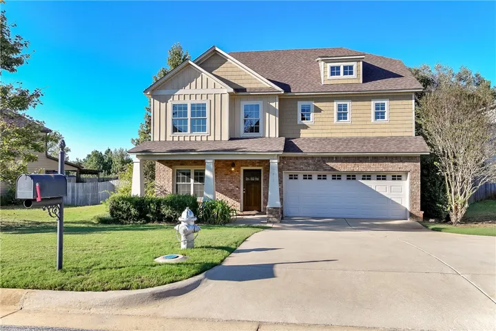 An inviting exterior features a concrete driveway leading to a two-car garage and front porch.