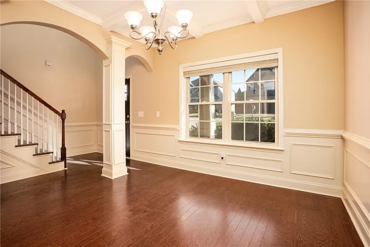 Rich wood floors and elegant wainscoting define this welcoming formal space.