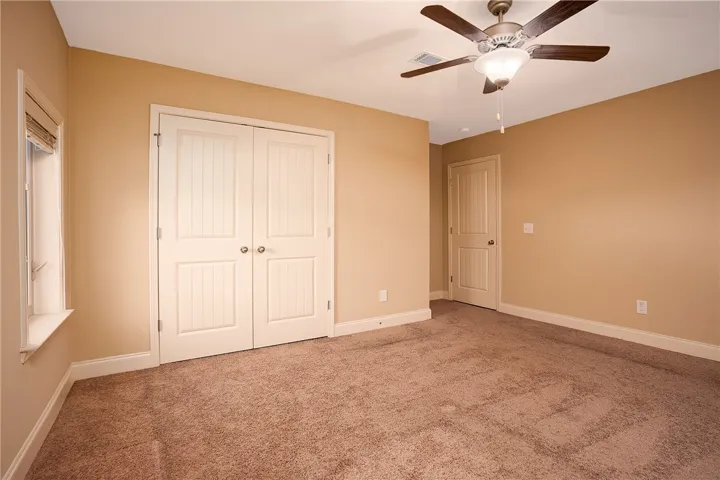 Soft carpeting underfoot defines this comfortable bedroom featuring classic paneled doors and wide baseboards.