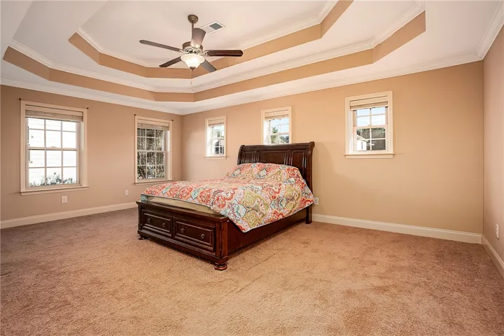 An elegant tray ceiling with classic molding defines this comfortable, carpeted main suite.