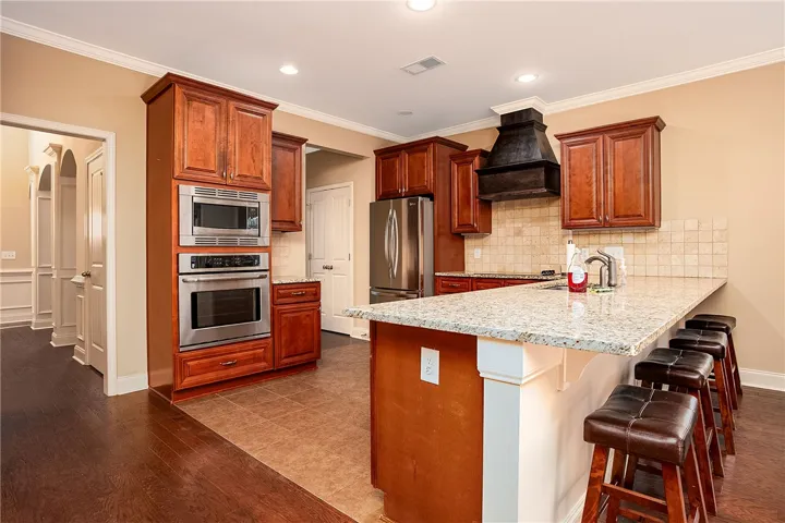 Rich wood cabinetry contrasts beautifully with granite countertops in this functional culinary space.