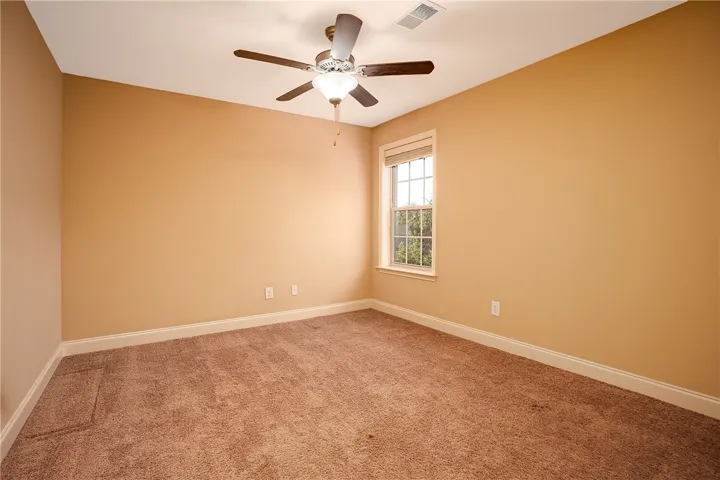 Warm wall tones and plush carpeting create a cozy atmosphere in this bedroom.