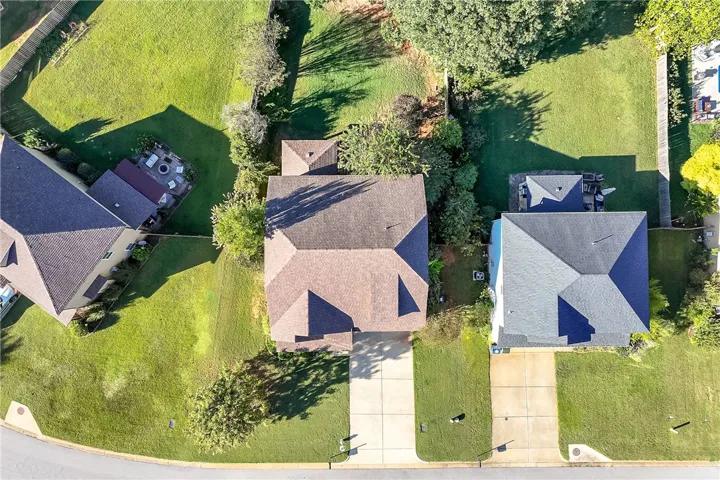 Aerial perspective reveals the home nestled on a lush lot with a private yard.