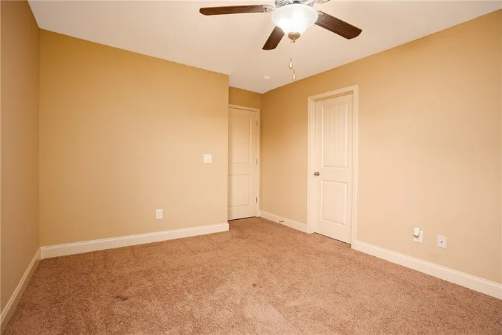 Warm-toned walls and plush carpeting create a cozy, inviting atmosphere in this versatile space.