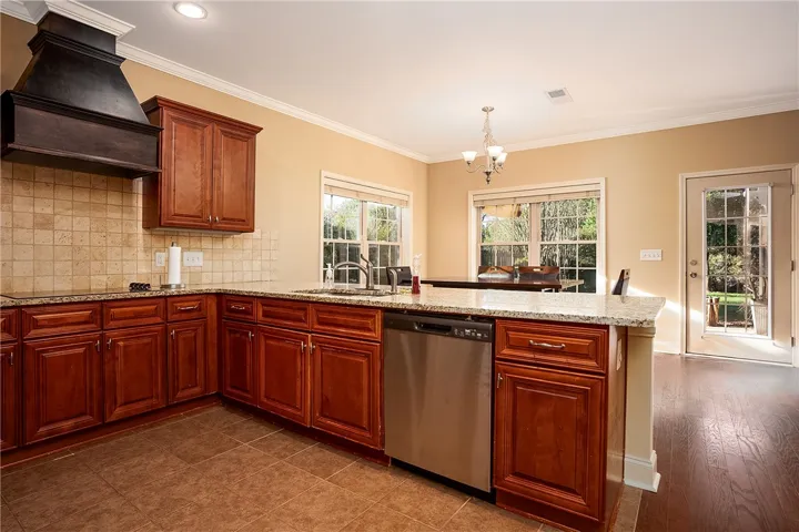 Rich wood cabinetry and stone countertops anchor this spacious kitchen designed for entertaining.