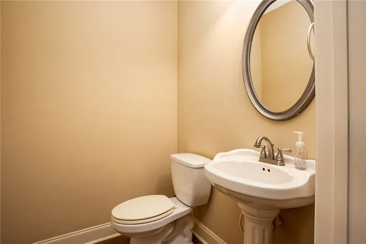 A classic pedestal sink pairs with warm-toned walls in this powder room.