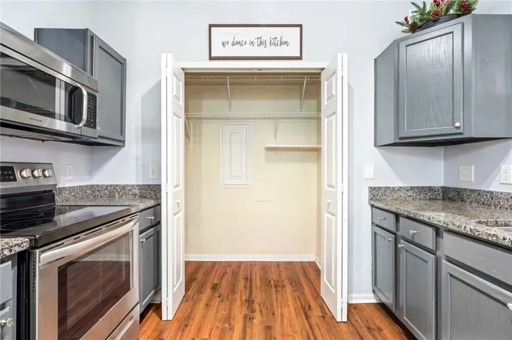 A spacious built-in pantry connects seamlessly with the modern kitchen cabinetry and warm wood flooring.