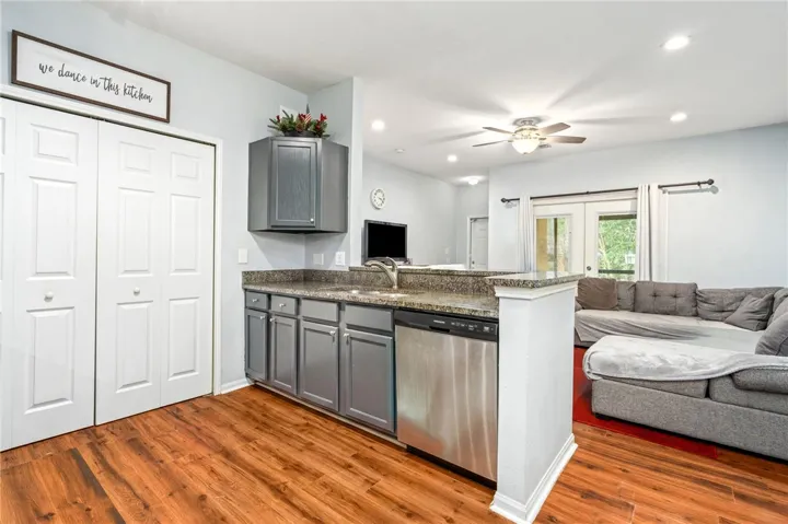 Gleaming hardwood floors and stone countertops anchor this inviting open-concept kitchen and living area.