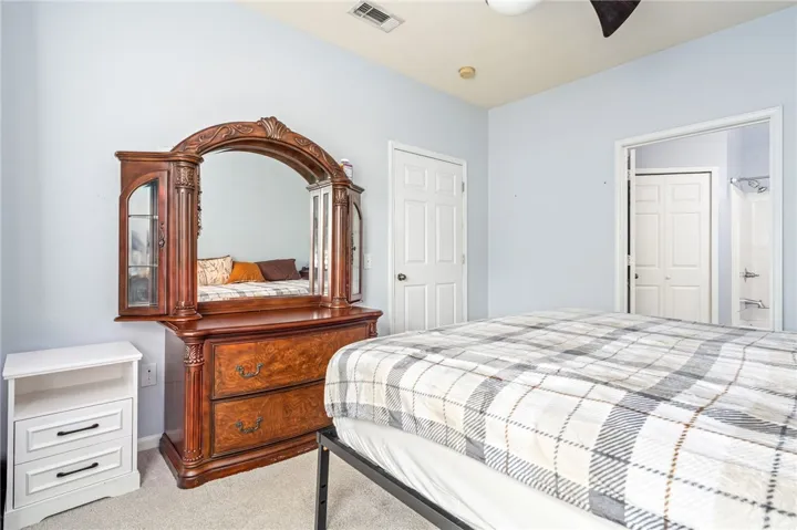 High ceilings and soft carpet floor define this comfortable bedroom space.