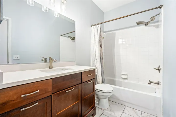 A spacious vanity with ample storage sits adjacent to a classic tub and shower combination.