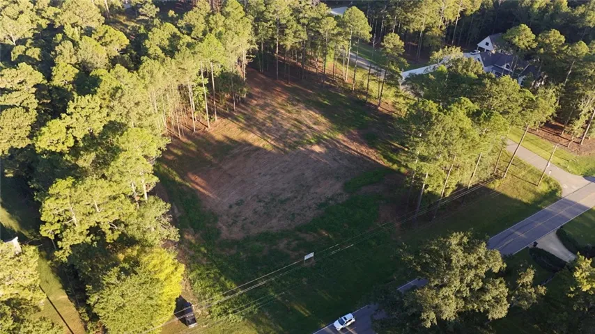 A cleared building site nestled among mature trees offers the perfect canvas for custom construction.