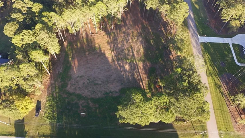 A cleared building site nestled among mature trees offers the perfect canvas for a custom home.