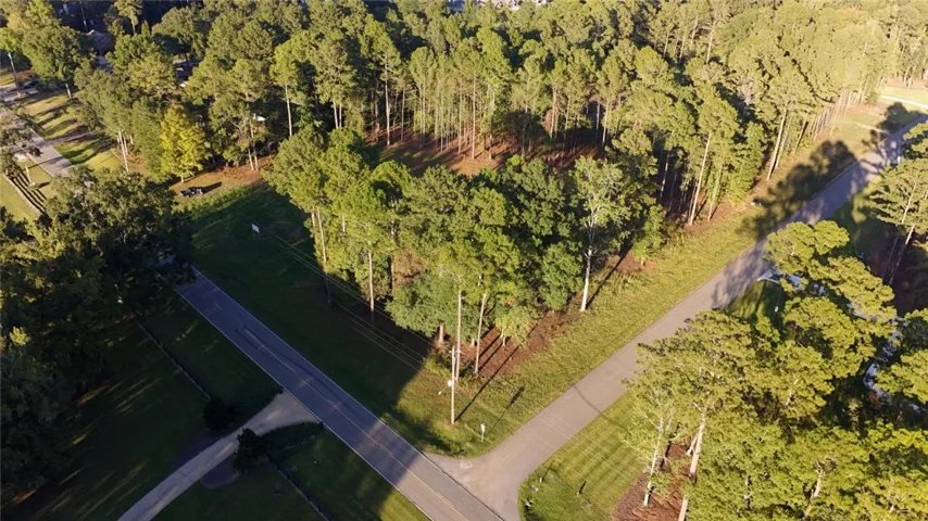 Mature trees frame a quiet road intersection on this scenic wooded homesite.