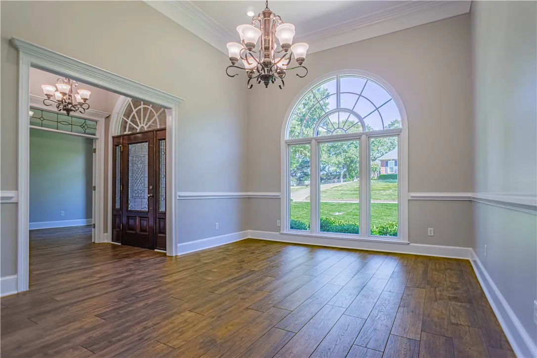 Gleaming hardwood floors and a grand arched window anchor this stately dining space.