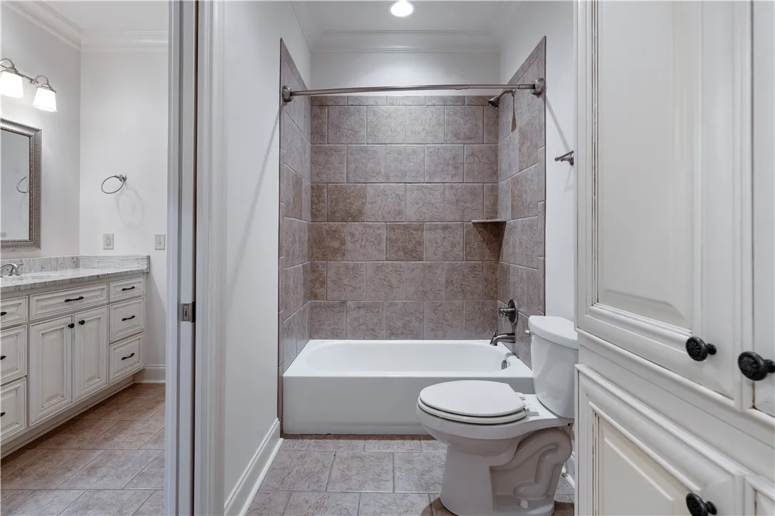 Upstairs. Tiled tub surround and crown molding define this classic guest bath layout.
