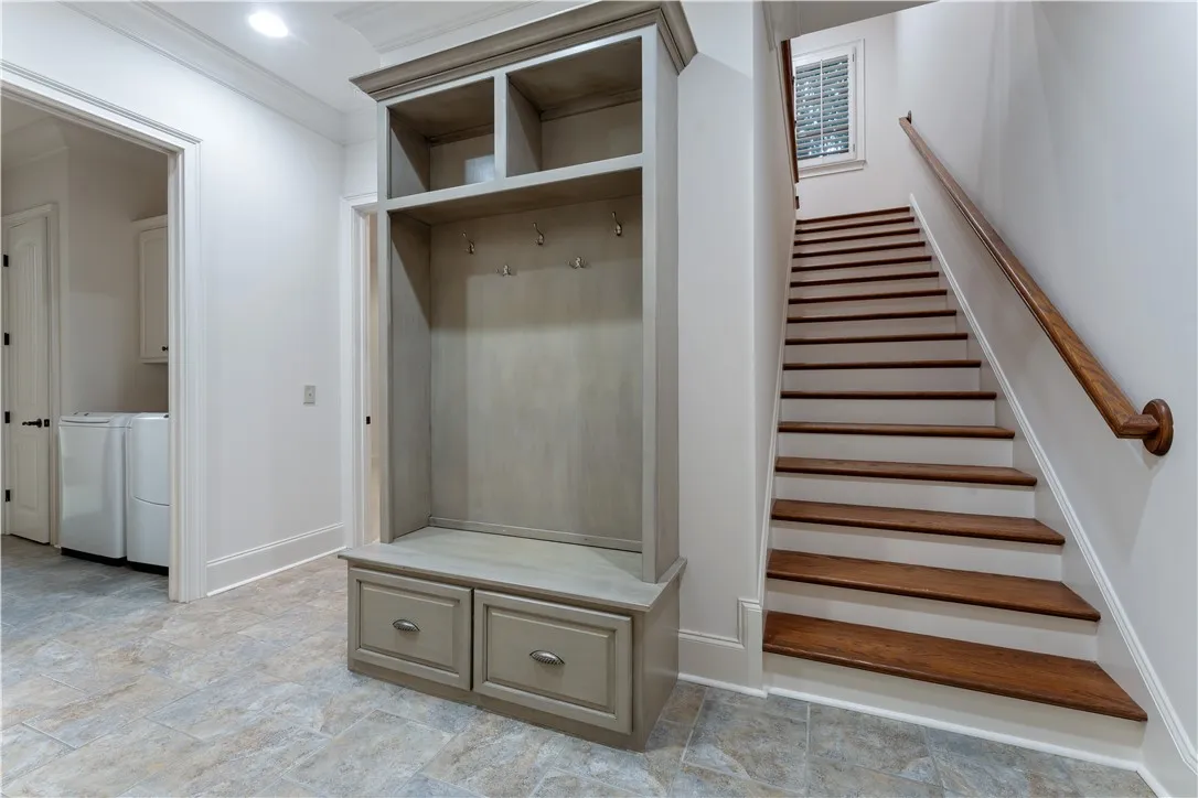 A custom drop zone sits adjacent to the staircase and nearby laundry area.