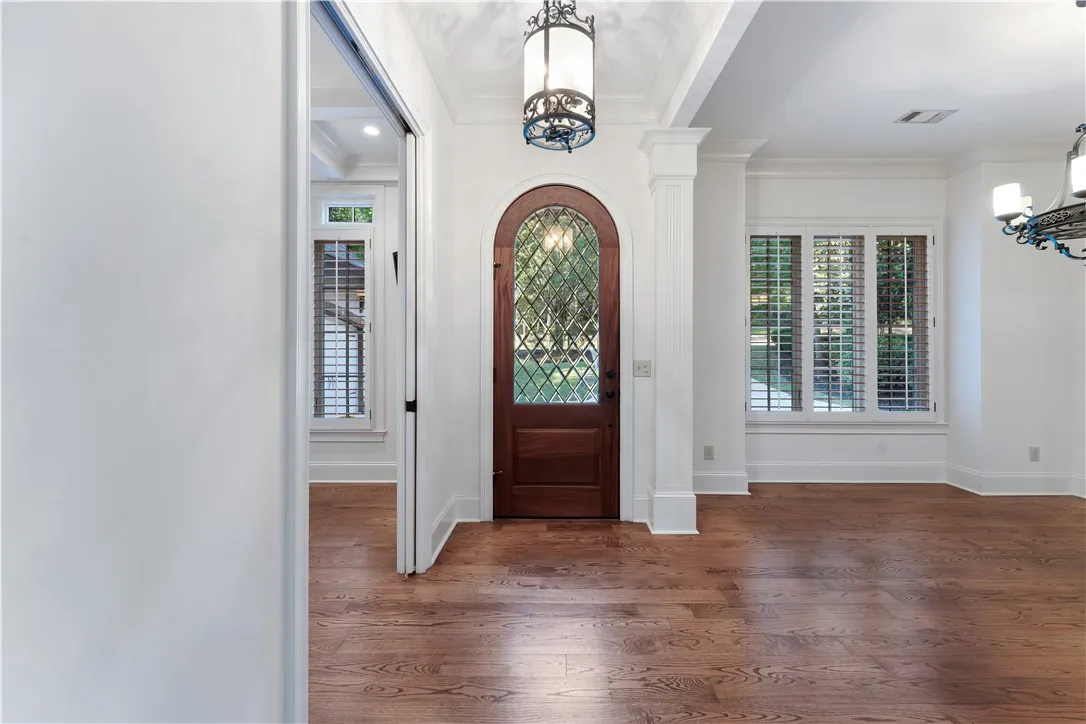 Gleaming hardwood floors and a classic arched entryway welcome guests into this elegant foyer.