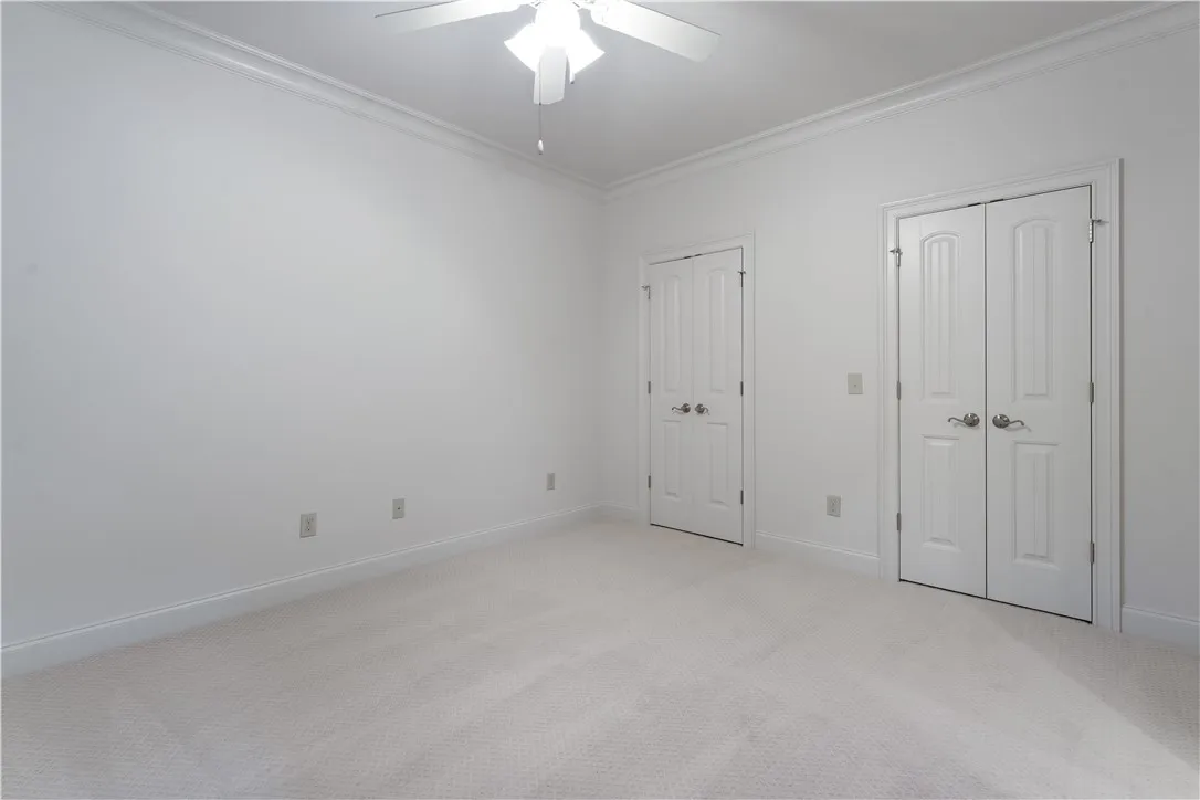 Upstairs. Plush carpeting and classic crown molding elevate this versatile secondary bedroom space.