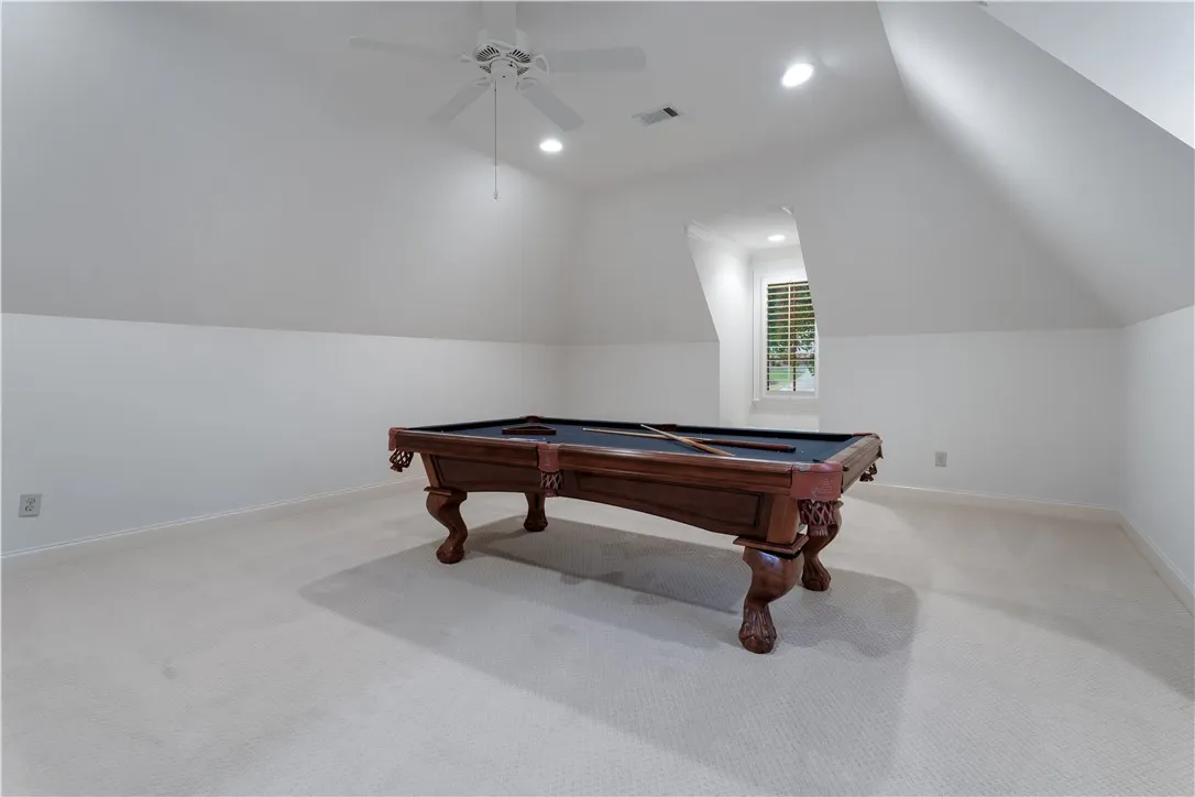 Upstairs. Slanted ceilings and recessed lighting define this versatile upper-level recreation space.