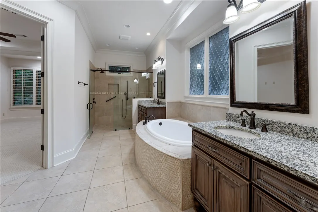 An elegant soaking tub serves as the centerpiece of this bathroom alongside granite-topped​​‌​​​​‌​​‌‌​‌‌​​​‌‌​‌​‌​‌​​​‌​​ vanities.