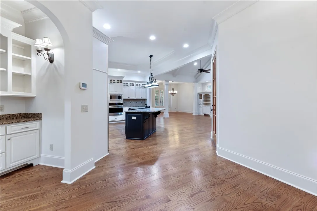 Gleaming hardwood floors sweep through an airy open layout under soaring high ceilings.