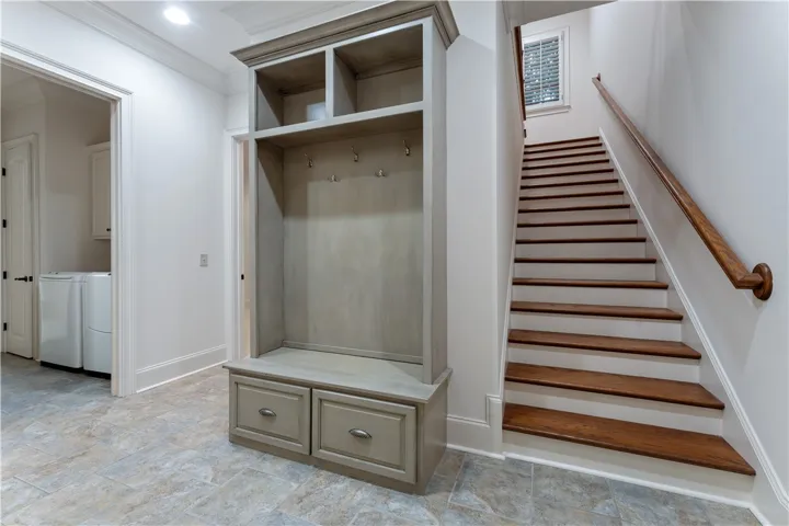 A custom drop zone sits adjacent to the staircase and nearby laundry area.