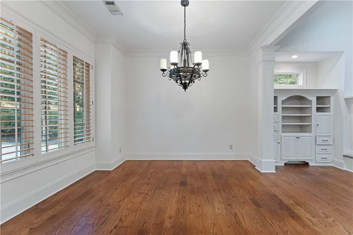 Rich hardwood floors and elegant crown molding define this open dining area.