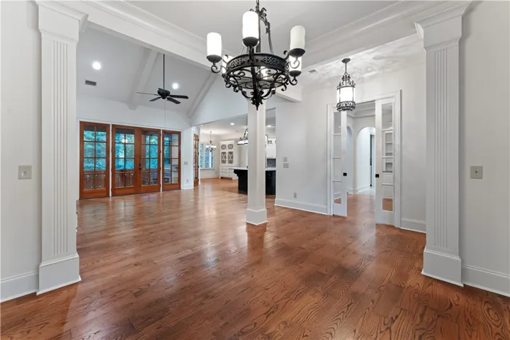 Rich hardwood floors and elegant classical columns frame this graceful, open living area.