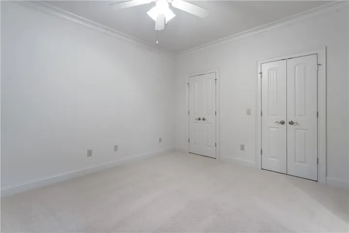 Upstairs. Plush carpeting and classic crown molding elevate this versatile secondary bedroom space.