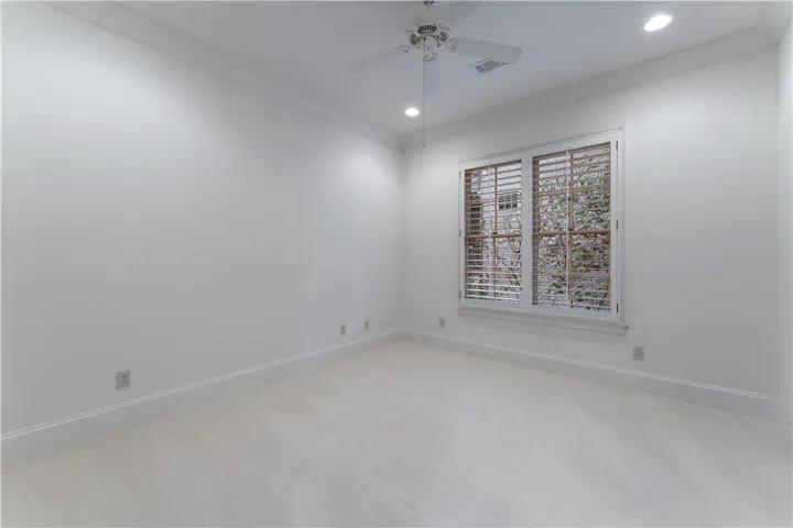 Crisp trim work and soft carpeting frame a bright window in this versatile bedroom.