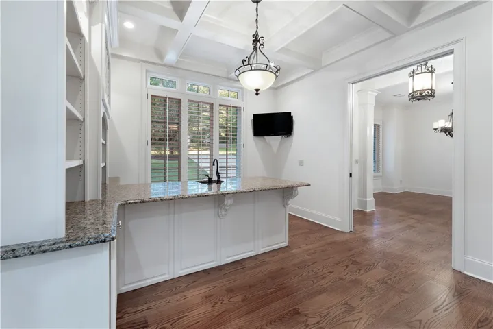 Gleaming hardwood floors and a coffered ceiling elevate this well-appointed butler pantry area.