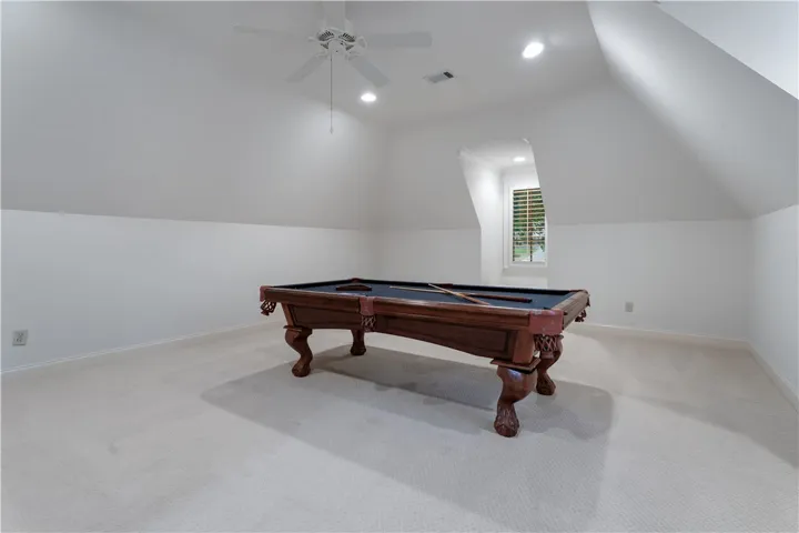 Upstairs. Slanted ceilings and recessed lighting define this versatile upper-level recreation space.