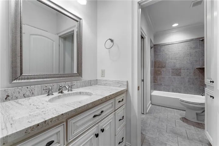 Upstairs. Polished granite countertops and classic tile details define this elegant bathroom space.