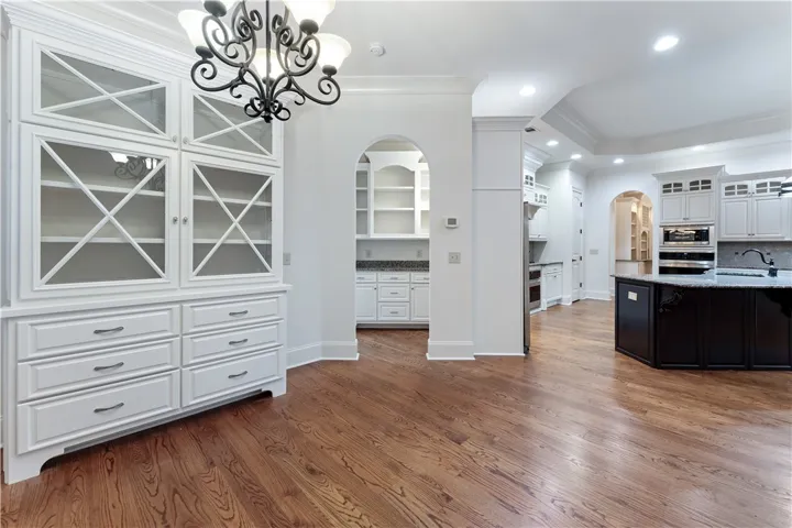 Gleaming hardwood floors and classic crown moldings enhance this elegant open kitchen space.