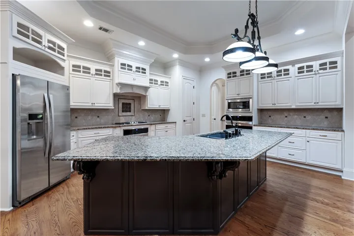 Granite countertops and detailed custom cabinetry highlight a spacious center island workspace.