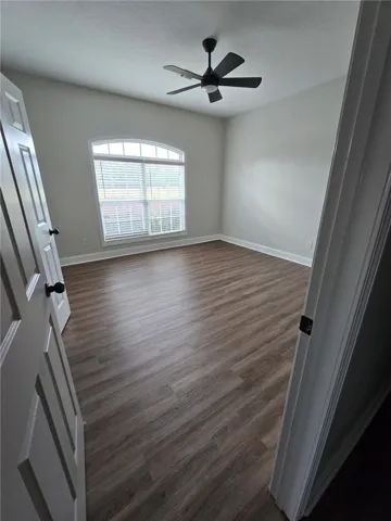 An arched window and warm wood-look flooring anchor this versatile secondary space.