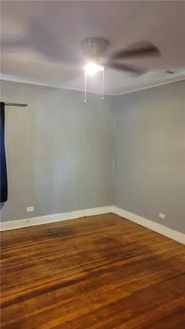Rich hardwood flooring anchors this versatile room detailed with classic baseboards and molding.