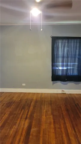 Classic hardwood floors anchor this bedroom ready for personal customization.
