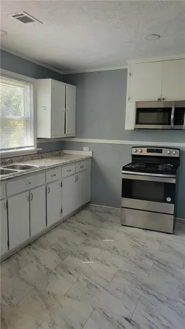 Laminate countertops and tile-look flooring anchor this practical culinary space.