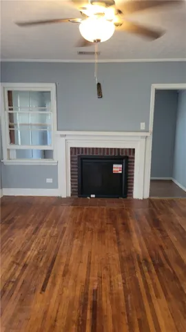 Rich hardwood floors and a classic fireplace mantle anchor this versatile living space.