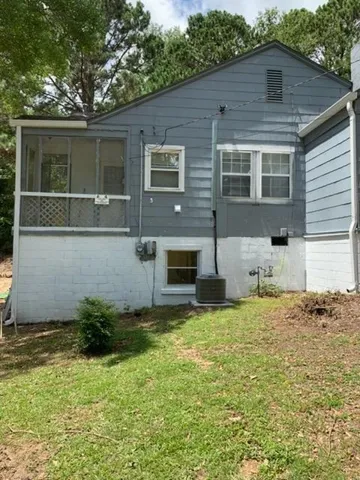 A sloping lawn leads up to the classic siding and raised foundation of this home.