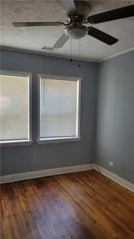 Warm hardwood floors and classic crown molding anchor this versatile space.