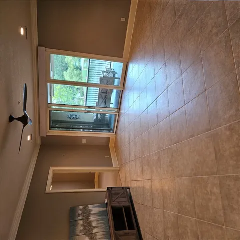 Crown molding and textured tile floors define this open living space leading outdoors.