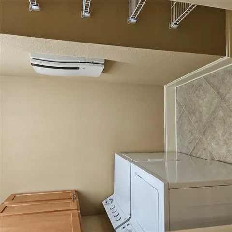Tucked-away laundry appliances stand ready beside durable tiled surfaces and clean-lined built-ins.