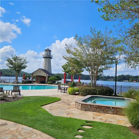 Lakeside views frame the community pool, hot tub, and stone terrace.