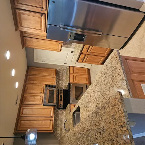 Gleaming granite countertops pair beautifully with warm wood cabinetry in this well-appointed kitchen.