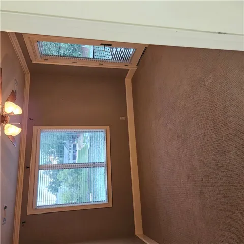 High ceilings and soft carpeting anchor this inviting space illuminated by tall windows.